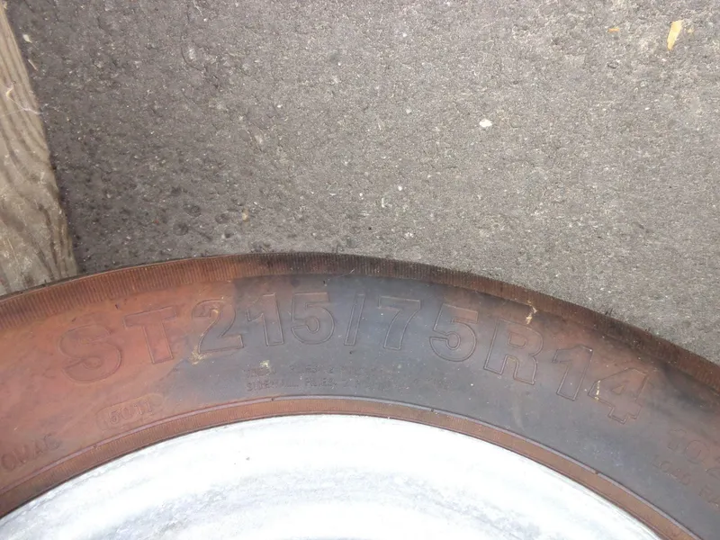 Slide: The Image of Close-up of a tire with markings "ST215/75R14" on a 2009 Glastron GT 185. - 23