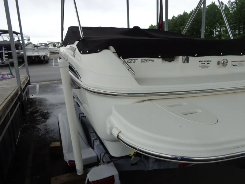 Slide: The Image of 2009 Glastron GT 185 boat with cover, parked on trailer in marina. - 25