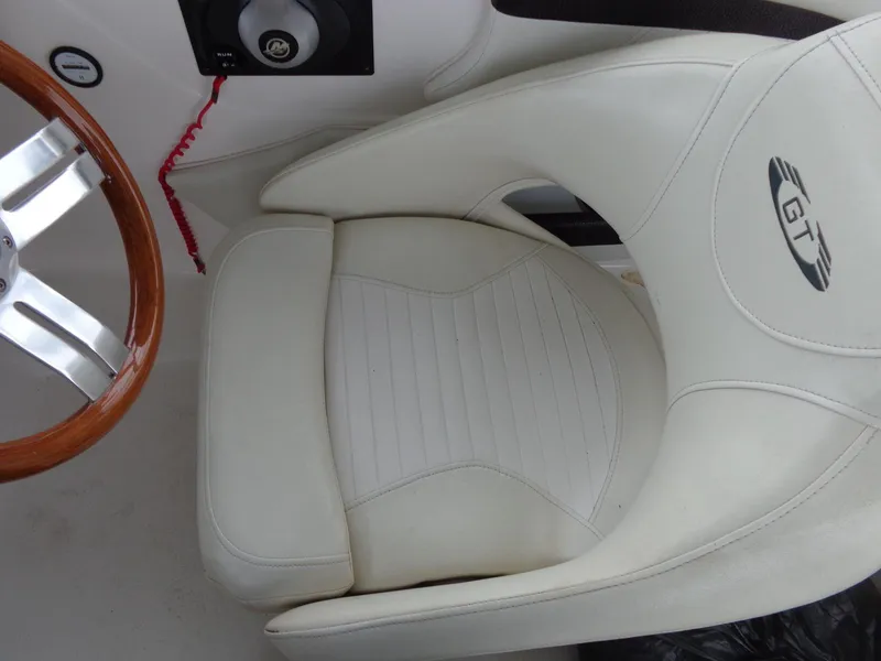 Slide: The Image of 2009 Glastron GT 185 boat interior with white seat and wooden steering wheel. - 38