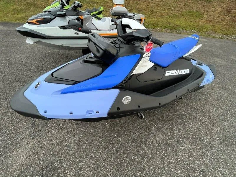 Slide: The Image of 2024 Sea-Doo Spark jet ski, blue and black, parked on asphalt. - 10