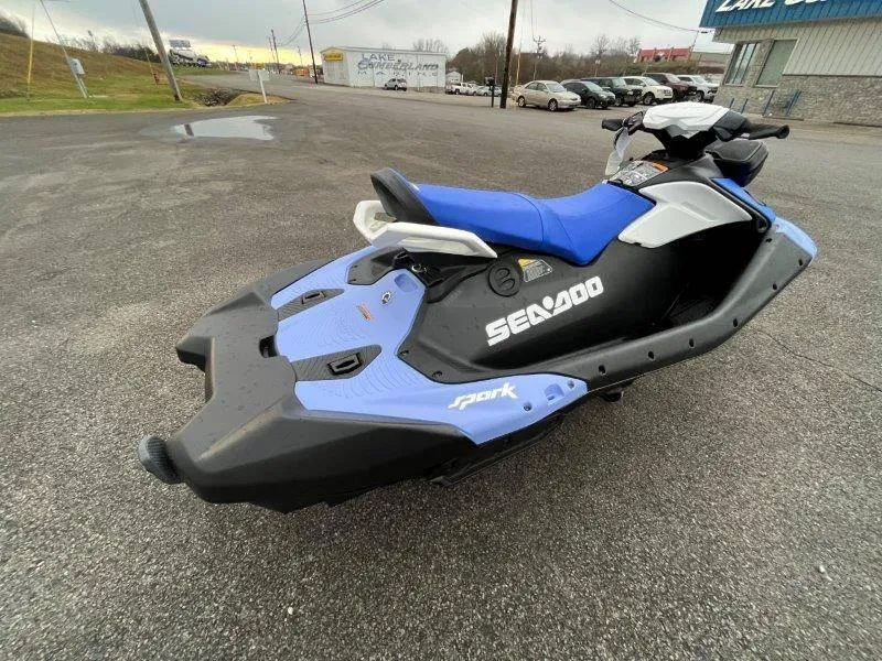 Slide: The Image of 2024 Sea-Doo Spark jet ski with blue seat, parked on asphalt. - 13
