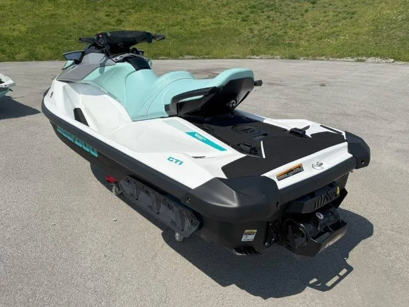 Slide: The Image of 2024 Sea-Doo GTI 130 jet ski, white and teal, parked on pavement. - 21