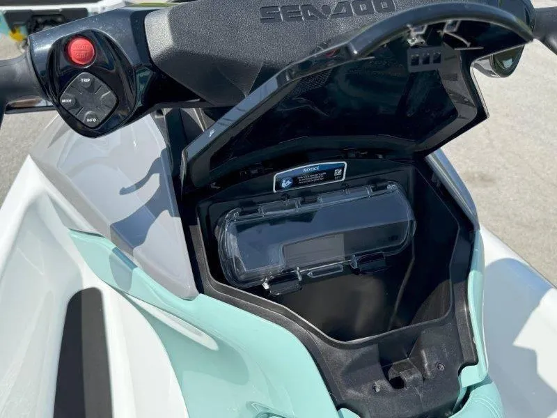 Slide: The Image of 2024 Sea-Doo GTI 130 storage compartment with control panel and open lid. - 24
