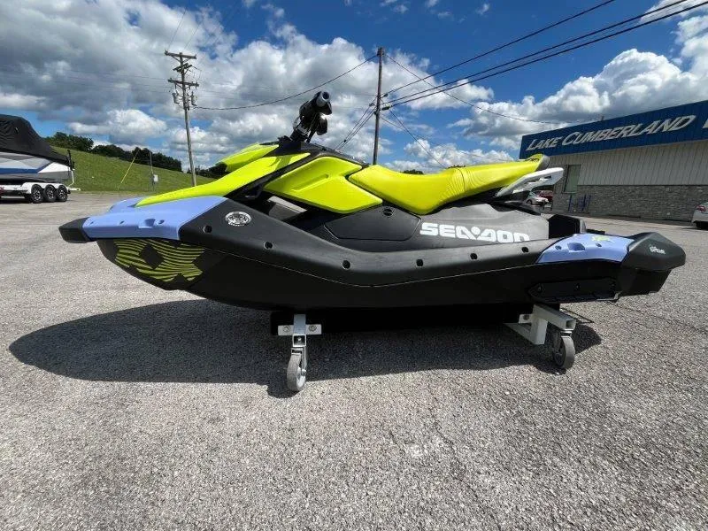 Slide: The Image of 2024 Sea-Doo Spark Trixx jet ski in vibrant yellow and black, parked outdoors. - 18