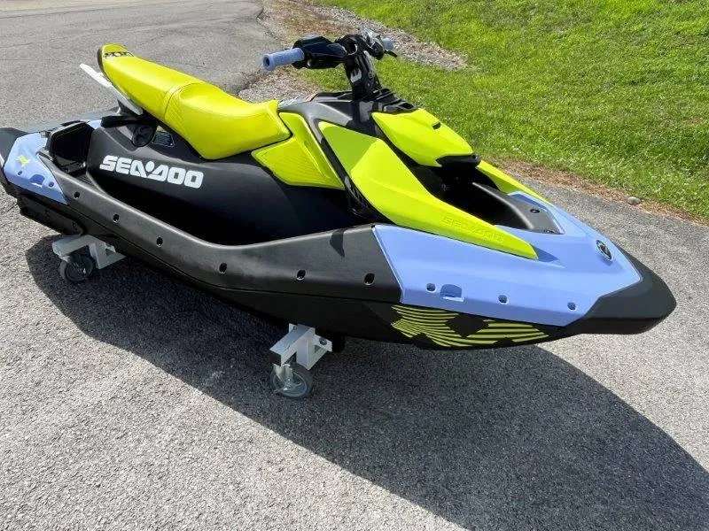 Slide: The Image of 2024 Sea-Doo Spark Trixx jet ski with vibrant yellow and black design on pavement. - 26