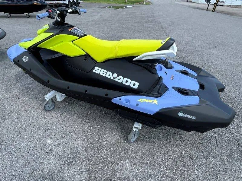 Slide: The Image of 2024 Sea-Doo Spark Trixx jet ski with vibrant yellow and blue design on pavement. - 3