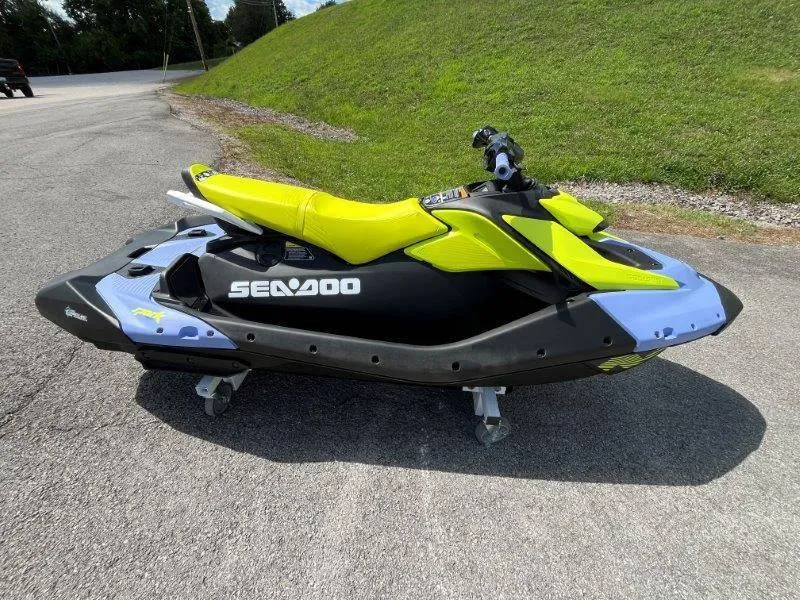 Slide: The Image of 2024 Sea-Doo Spark Trixx jet ski, vibrant yellow and black design, parked on pavement. - 4