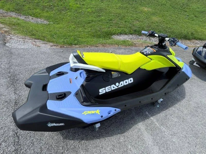 Slide: The Image of 2024 Sea-Doo Spark Trixx jet ski, vibrant yellow and blue design, parked on pavement. - 5