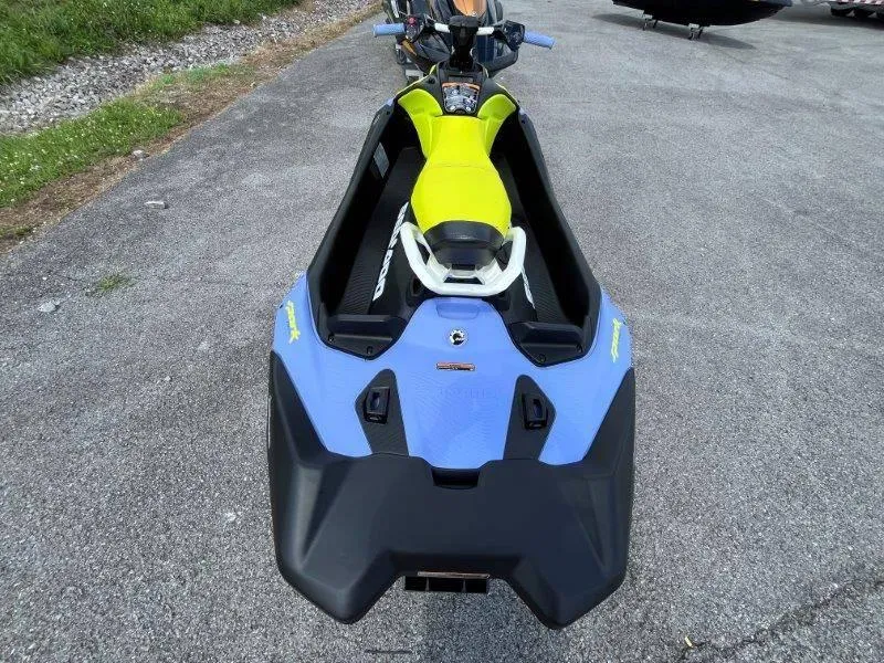 Slide: The Image of 2024 Sea-Doo Spark Trixx, blue and yellow, parked on pavement. - 6