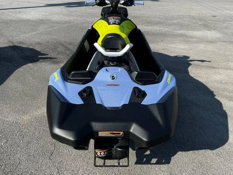 Slide: The Image of 2024 Sea-Doo Spark Trixx jet ski, rear view, vibrant colors, parked on pavement. - 21
