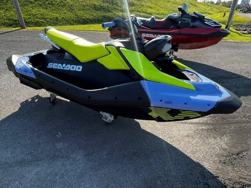 Slide: The Image of 2024 Sea-Doo Spark Trixx jet ski, vibrant yellow and black design, parked outdoors. - 29