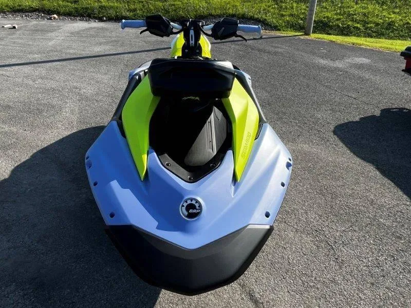 Slide: The Image of 2024 Sea-Doo Spark Trixx jet ski, vibrant yellow and blue design, parked on pavement. - 9