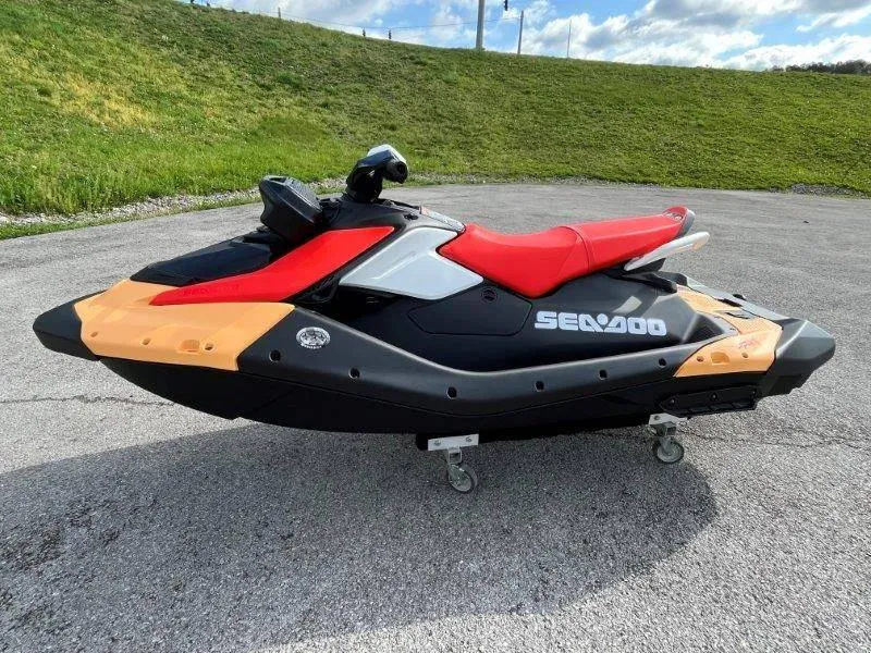 Slide: The Image of 2024 Sea-Doo Spark jet ski with red seat, parked on pavement. - 10