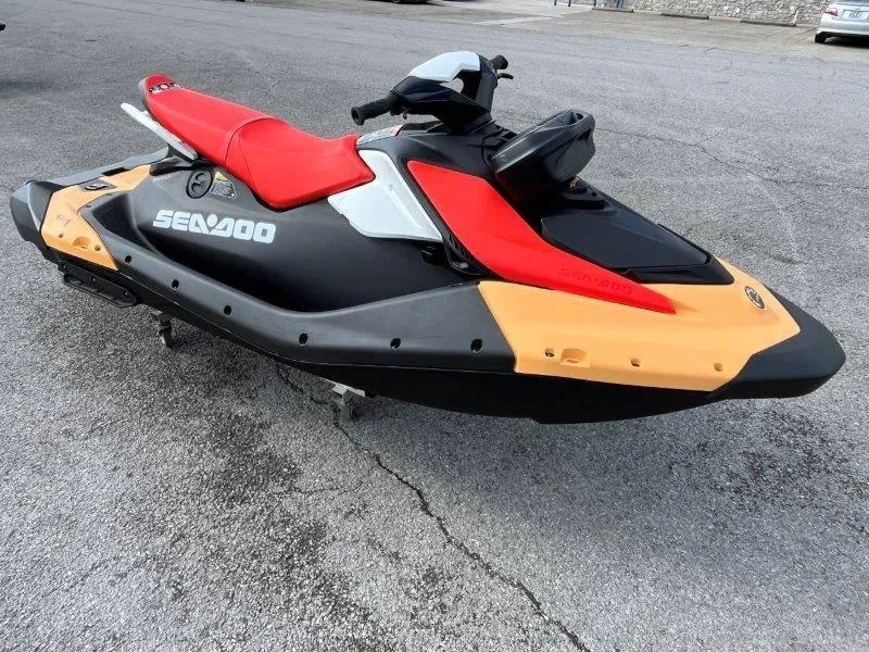 Slide: The Image of 2024 Sea-Doo Spark jet ski, red and black, parked on pavement. - 19