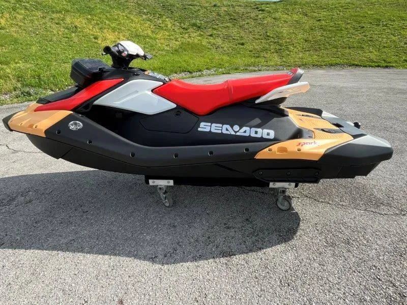 Slide: The Image of 2024 Sea-Doo Spark jet ski with red seat, parked on pavement. - 21