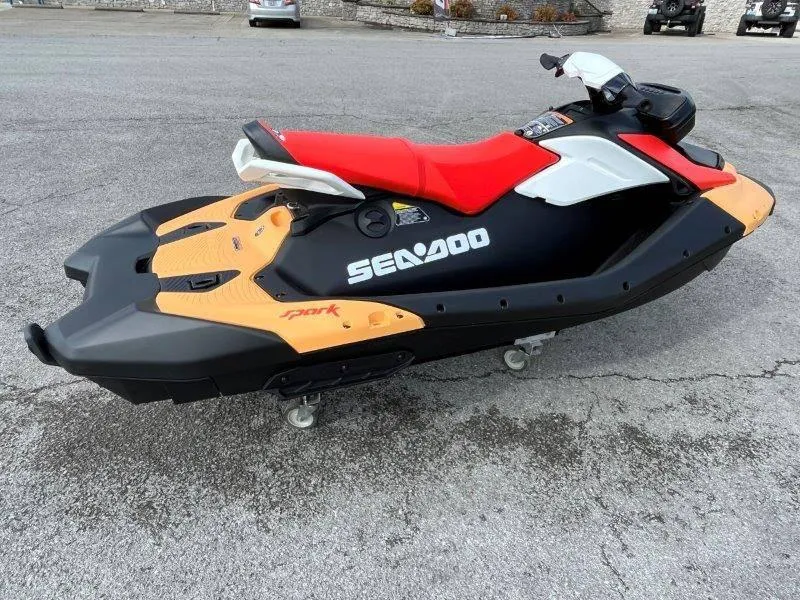 Slide: The Image of 2024 Sea-Doo Spark jet ski with red seat, black and orange body, on pavement. - 4