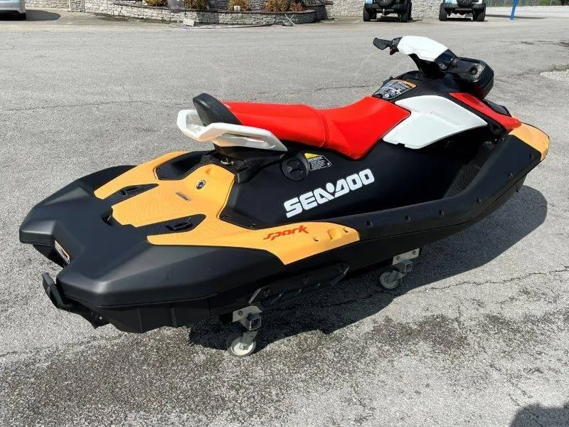 Slide: The Image of 2024 Sea-Doo Spark jet ski with red seat, black and yellow body, parked on pavement. - 5