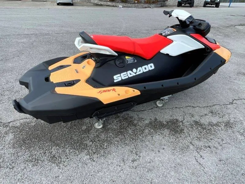 Slide: The Image of 2024 Sea-Doo Spark jet ski with red seat, black and orange body, on pavement. - 9