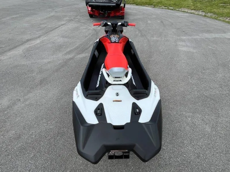 Slide: The Image of 2024 Sea-Doo Spark Trixx jet ski, red and white, parked on pavement. - 29