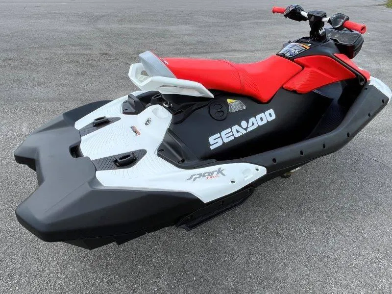 Slide: The Image of 2024 Sea-Doo Spark Trixx jet ski with red seat and black-white design. - 3