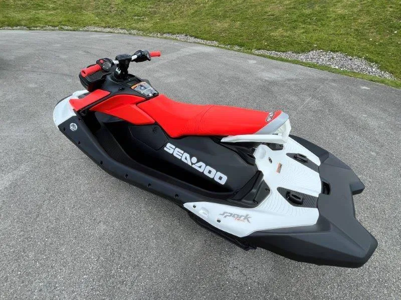 Slide: The Image of 2024 Sea-Doo Spark Trixx jet ski with red seat, parked on pavement. - 30