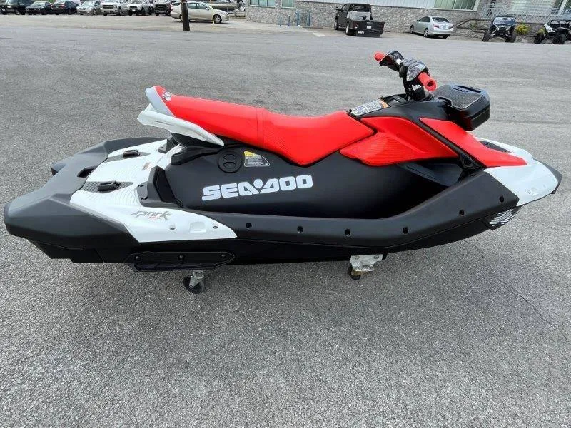 Slide: The Image of 2024 Sea-Doo Spark Trixx jet ski, red and black, parked on pavement. - 5