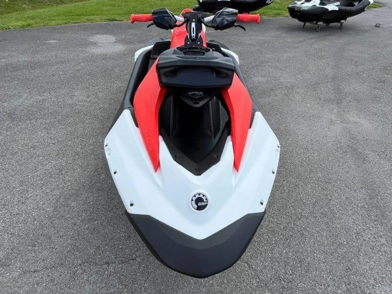 Slide: The Image of 2024 Sea-Doo Spark Trixx jet ski, red and white, front view on pavement. - 6