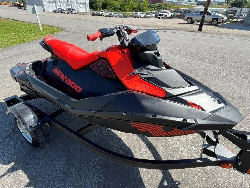 Slide: The Image of 2022 Sea-Doo Spark Trixx 3 Up Sound on trailer, vibrant red and black design. - 17