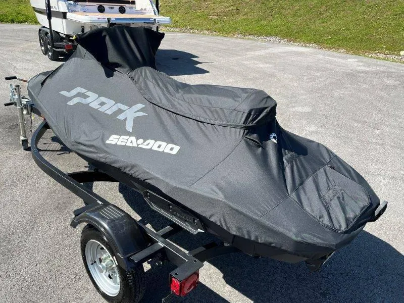 Slide: The Image of 2022 Sea-Doo Spark Trixx 3 Up Sound covered on trailer in outdoor setting. - 24