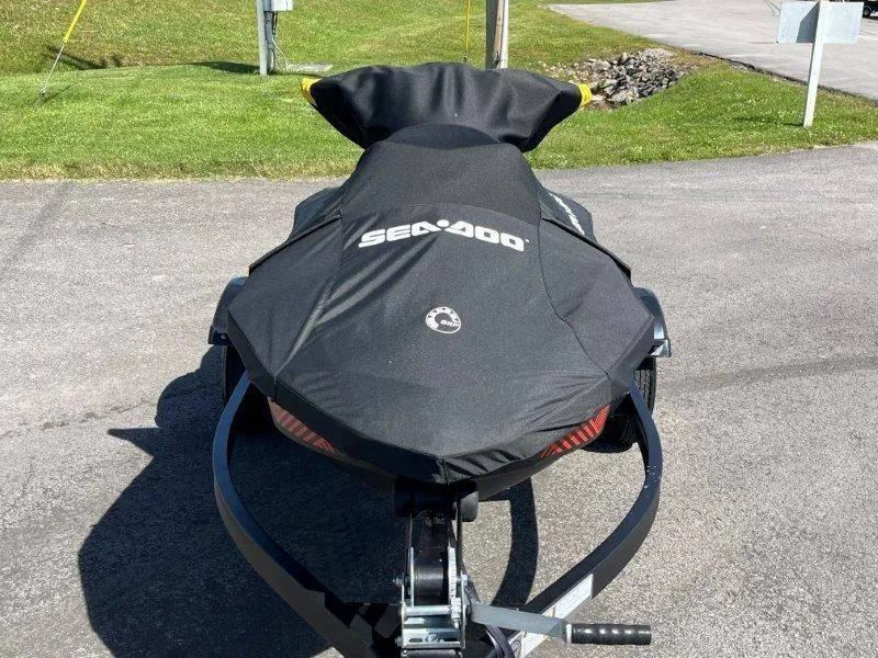 Slide: The Image of 2022 Sea-Doo Spark Trixx 3 Up Sound covered on trailer, parked on pavement. - 29