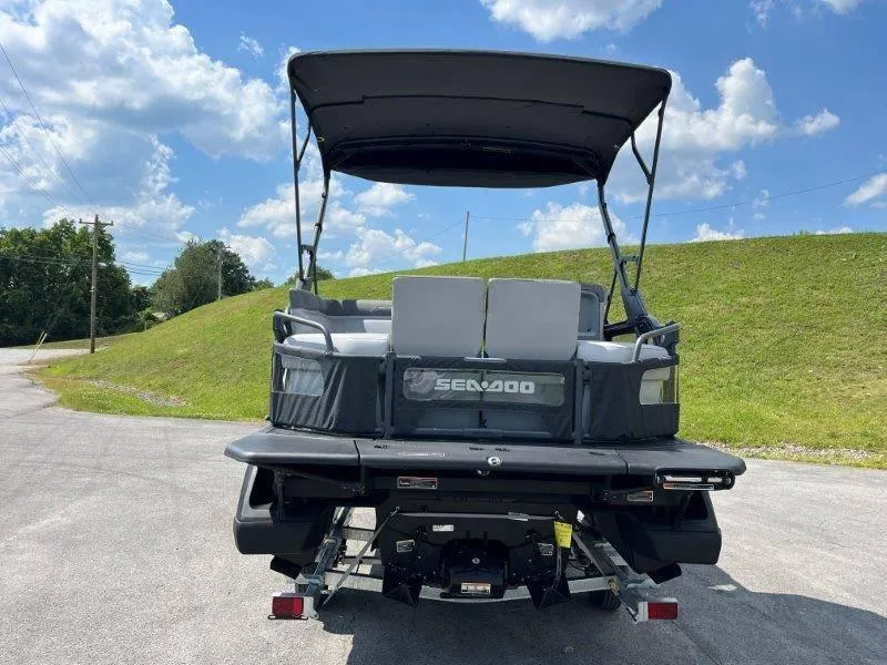 Slide: The Image of 2024 Sea-Doo Switch Cruise 18' 230hp boat, rear view, parked outdoors under blue sky. - 13
