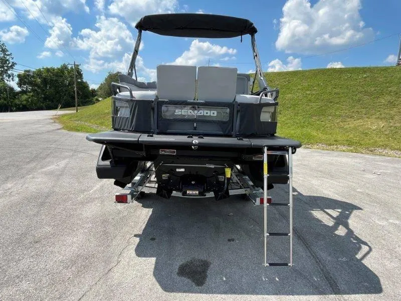 Slide: The Image of 2024 Sea-Doo Switch Cruise 18' 230hp boat, rear view with ladder, parked outdoors. - 46
