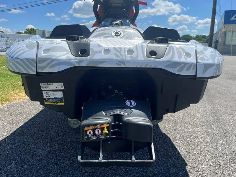 Slide: The Image of 2024 Sea-Doo Spark 1UP Trixx 90 Sound, rear view on pavement. - 13