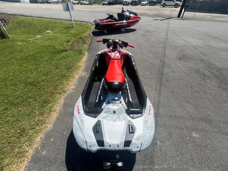 Slide: The Image of 2024 Sea-Doo Spark 1UP Trixx 90 Sound jet ski on pavement, vibrant red seat. - 16
