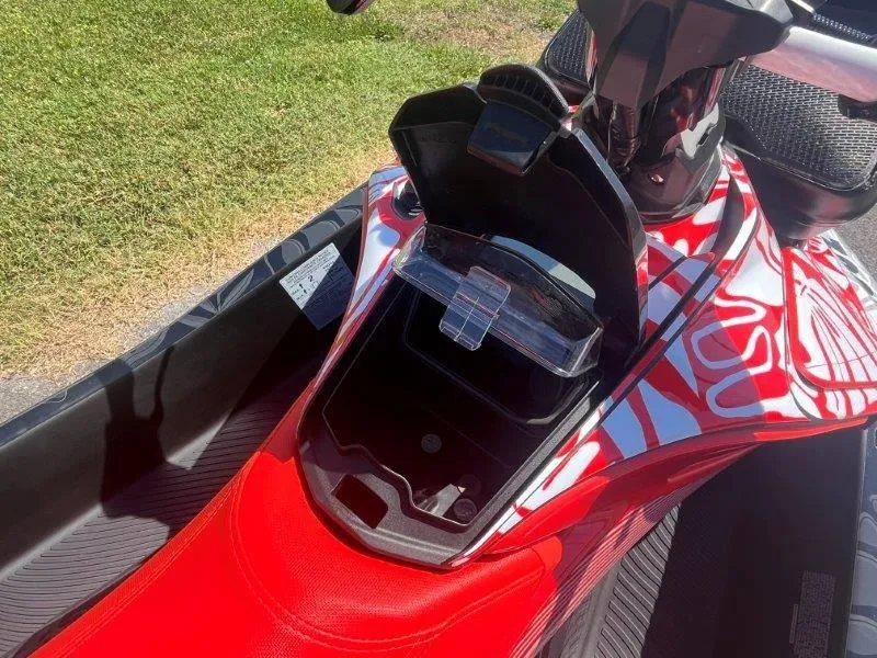 Slide: The Image of 2024 Sea-Doo Spark 1UP Trixx 90 Sound, open storage compartment, vibrant red design. - 22