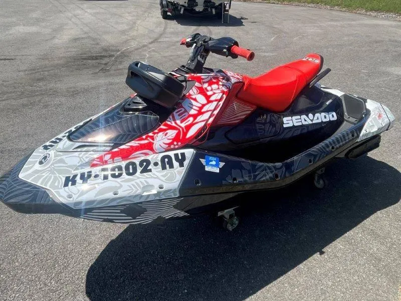 Slide: The Image of 2024 Sea-Doo Spark 1UP Trixx 90 Sound jet ski with vibrant red and black design. - 3