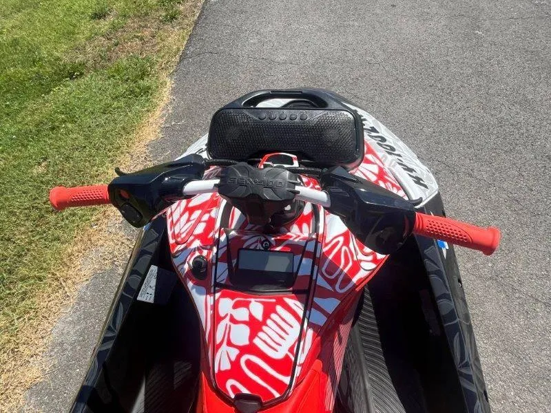 Slide: The Image of 2024 Sea-Doo Spark 1UP Trixx 90 Sound, vibrant red design, parked on pavement. - 30