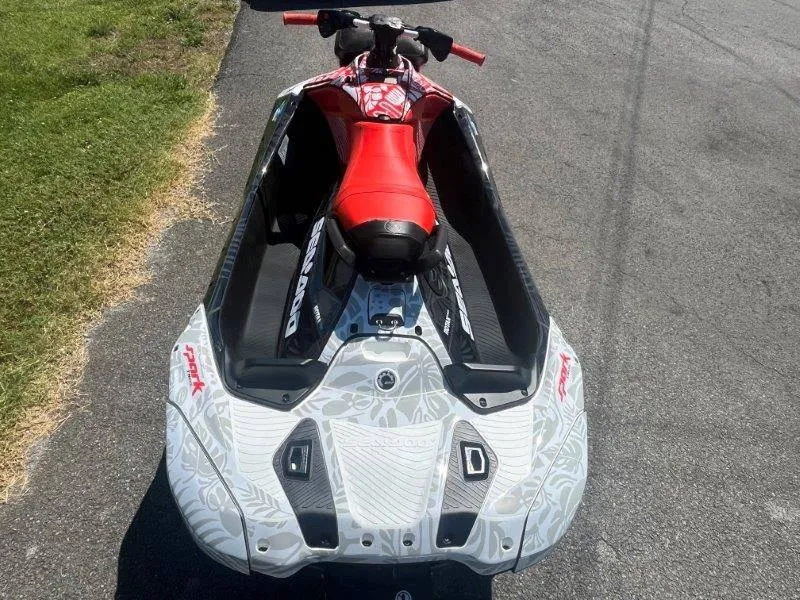 Slide: The Image of 2024 Sea-Doo Spark 1UP Trixx 90 Sound, red seat, parked on pavement. - 4