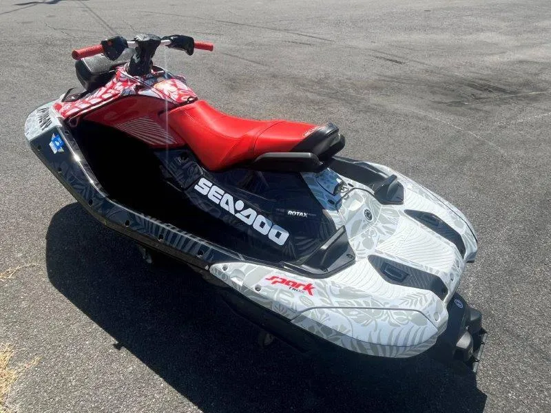Slide: The Image of 2024 Sea-Doo Spark 1UP Trixx 90 Sound, red seat, parked on asphalt. - 6