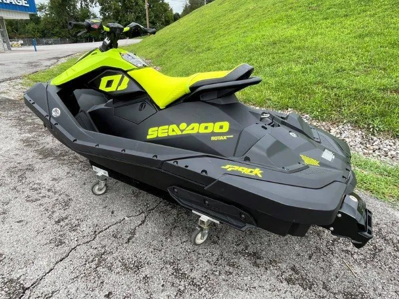 Slide: The Image of 2023 Sea-Doo SPARK TRIXX 2up jet ski, black and yellow, parked on pavement. - 11