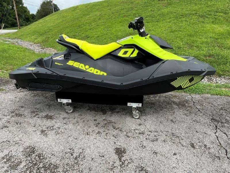 Slide: The Image of 2023 Sea-Doo SPARK TRIXX 2up jet ski, vibrant yellow and black, on display outdoors. - 23