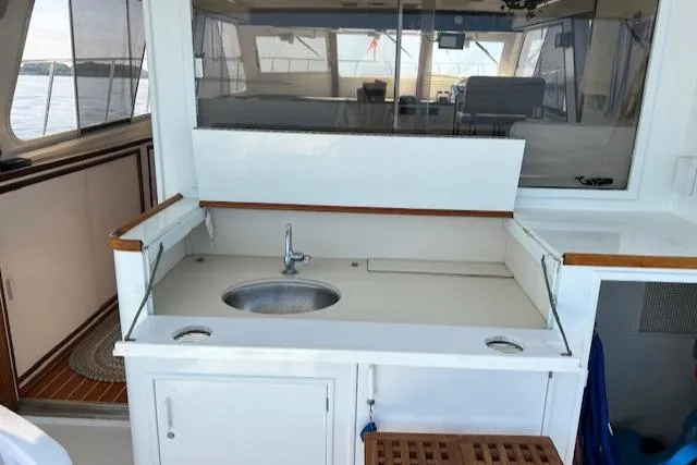 Slide: The Image of 1980 Huckins Sports Cruiser interior with sink and cabinetry. - 17