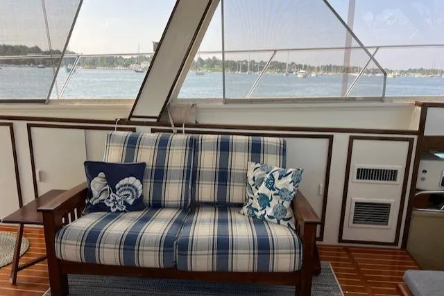 Slide: The Image of Interior of 1980 Huckins Sports Cruiser with plaid seating and nautical-themed pillows. - 21