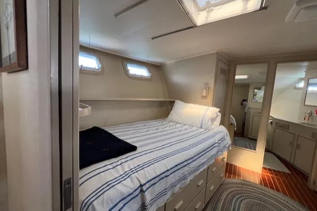 Slide: The Image of Cozy bedroom in 1980 Huckins Sports Cruiser with striped bedding and wooden flooring. - 23