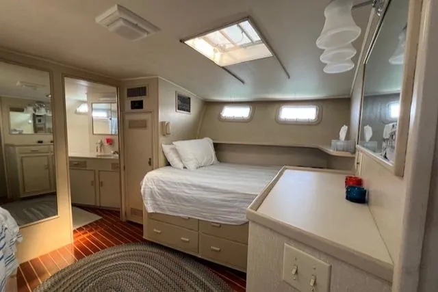 Slide: The Image of 1980 Huckins Sports Cruiser cabin with bed, skylight, and wooden flooring. - 24