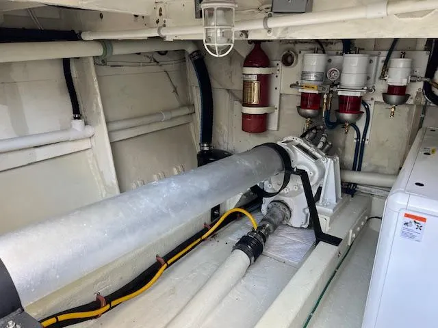 Slide: The Image of Engine room of 1980 Huckins Sports Cruiser with visible machinery and fire extinguisher system. - 31