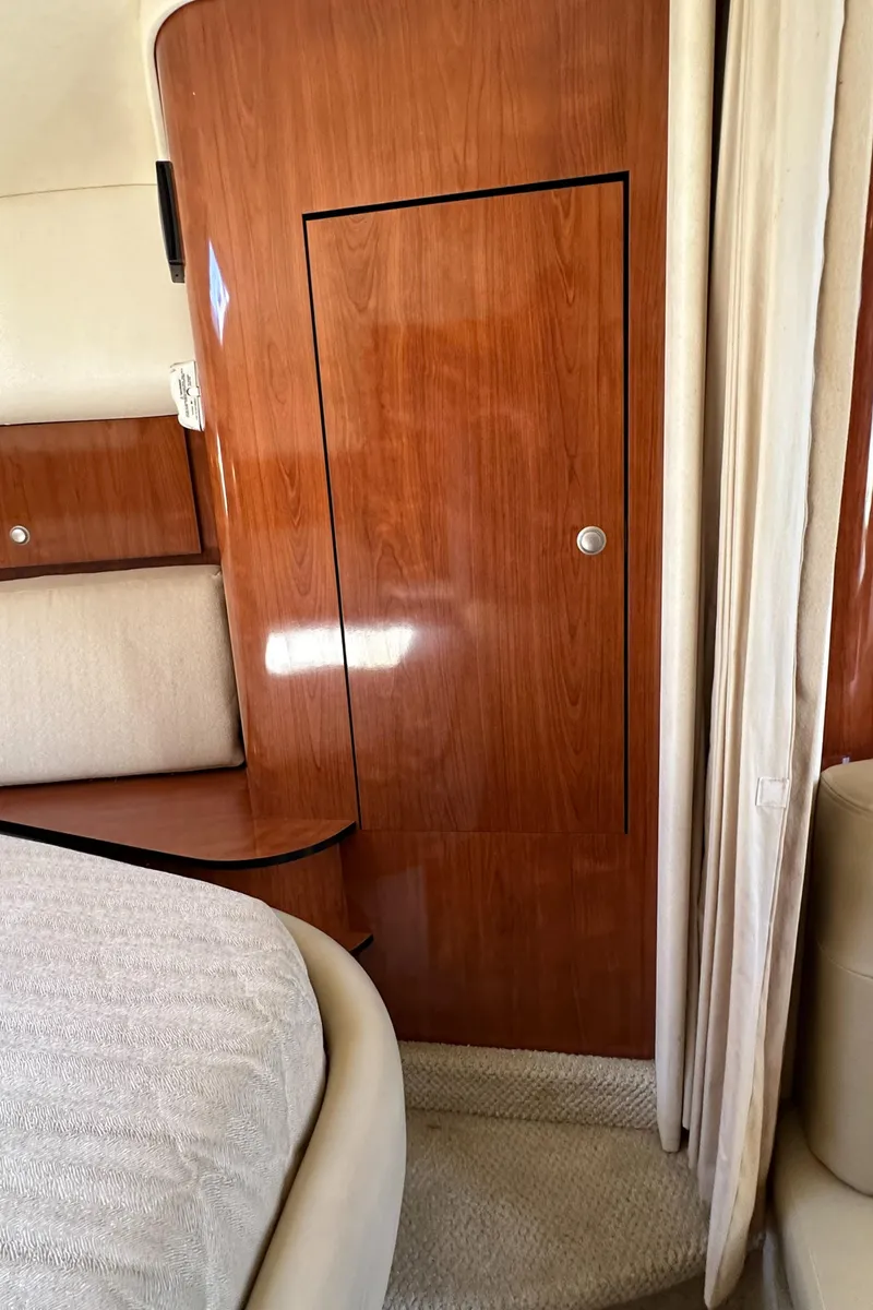 Slide: The Image of Interior cabin of 2007 Sea Ray 320 Sundancer with wood paneling and beige upholstery. - 40