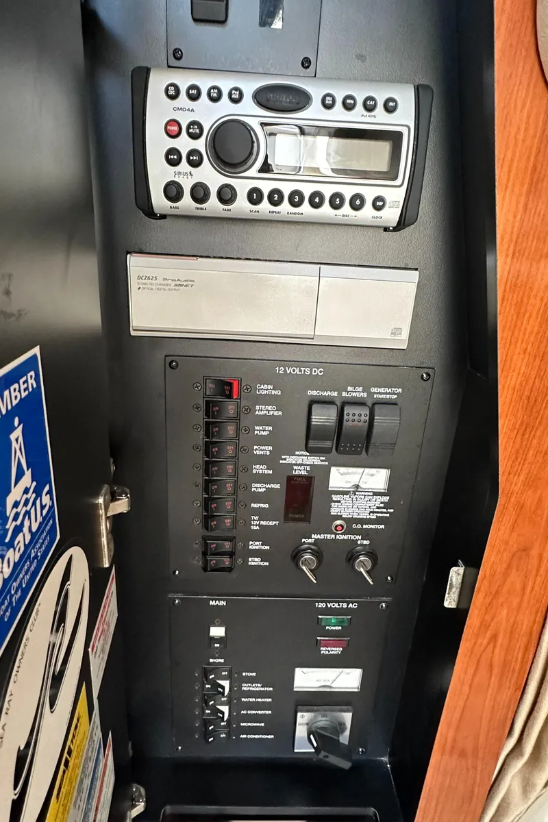 Slide: The Image of Control panel of a 2007 Sea Ray 320 Sundancer boat, featuring radio and electrical switches. - 41