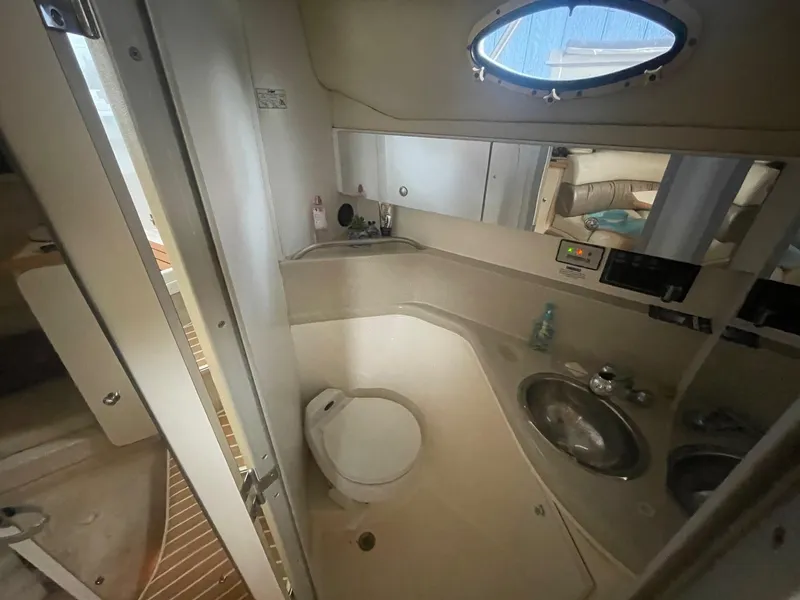 Slide: The Image of 1997 Wellcraft 3200 Martinique boat bathroom with sink, toilet, and mirror. - 12