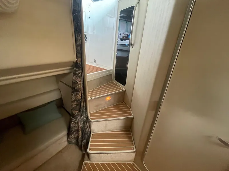 Slide: The Image of Interior of 1997 Wellcraft 3200 Martinique boat with wooden steps and cozy cabin space. - 9